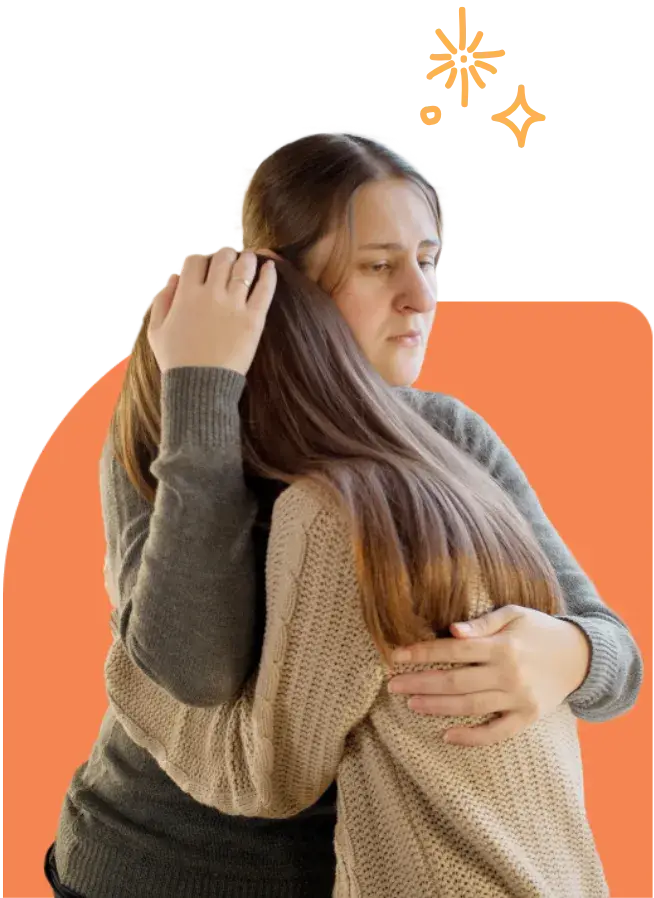 Two people hugging, showing emotion and support as they navigate how to deal with cyberbullying. One has long brown hair, and both are wearing sweaters. The background features an orange shape with small decorative stars.