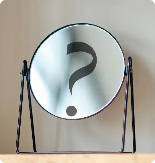 A circular mirror on a stand reflects a large question mark at its center, symbolizing the elusive answers we seek about the effects of porn addiction. The background is a neutral light color, enhancing the mirrors enigmatic presence.